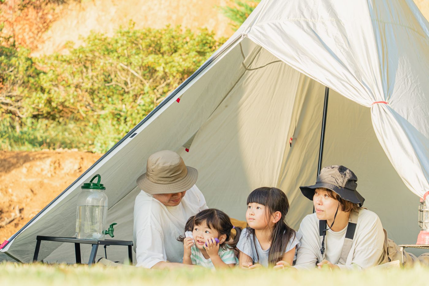 キャンプ場のテントで寝転ぶ家族