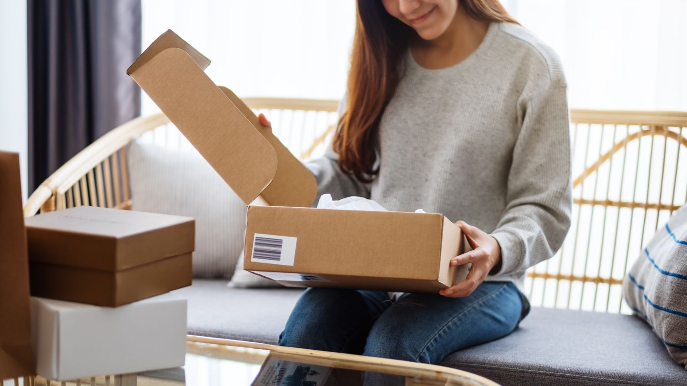 届いた段ボール箱を開ける女性